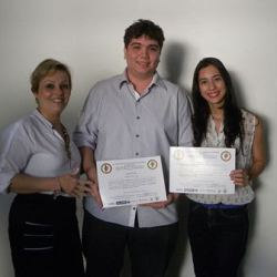 Entrega do certificado de apresentação pela Profa. Dra. Andrea Pires, para os alunos Matheus Cardoso Silva e Ana Paula Ahid