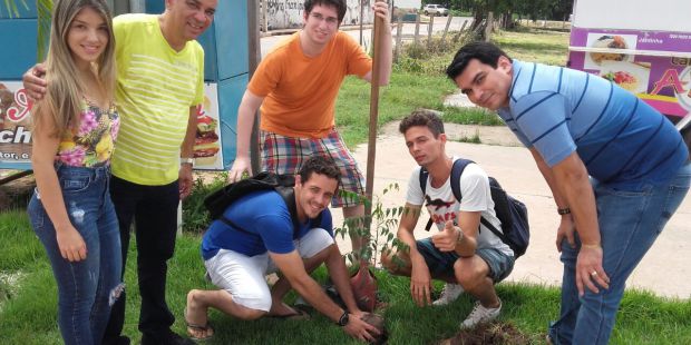 O gestor do campus, juntamente com os alunos na distribuição das mudas de planta.